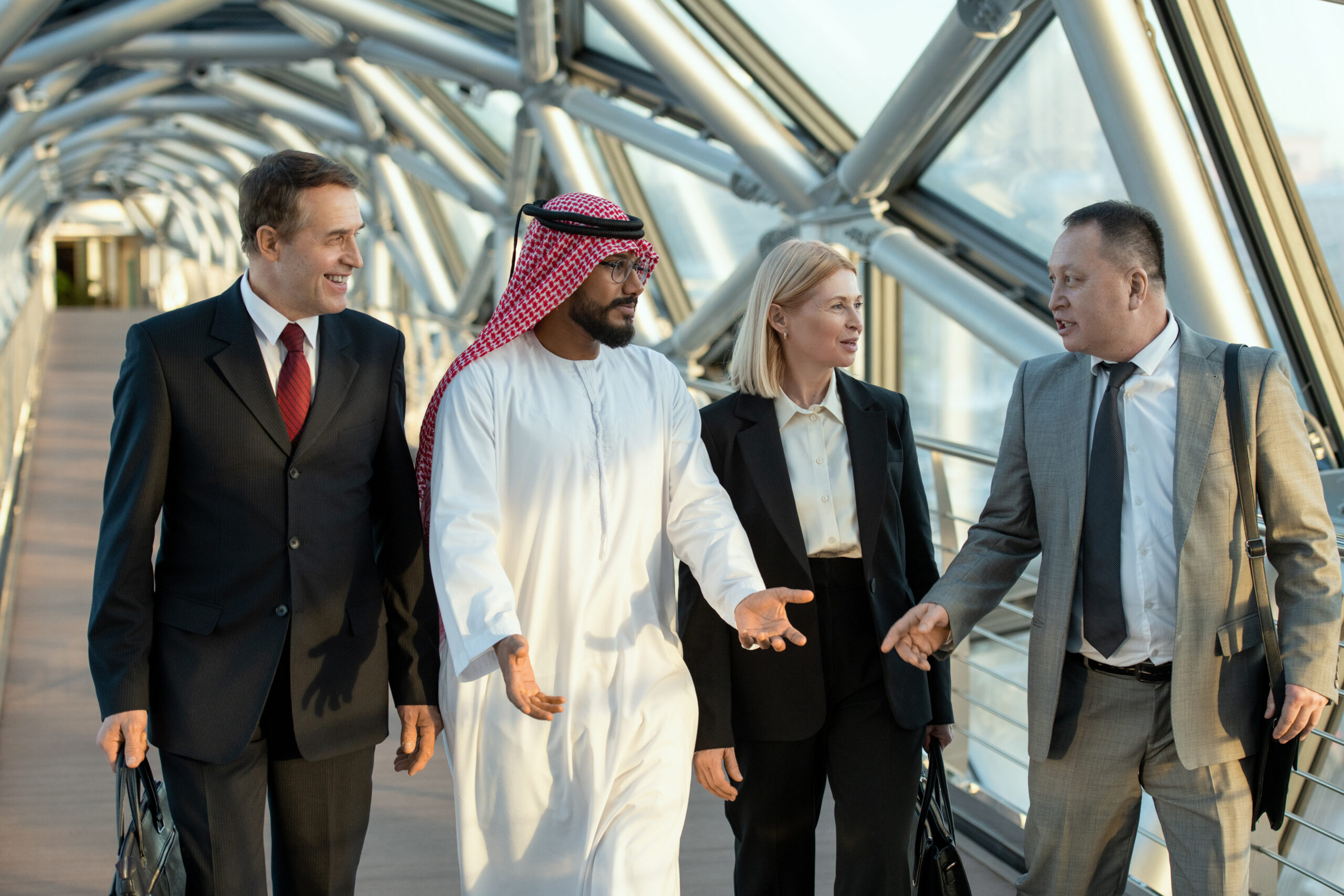 A group of people walking down aisle and having discussion A group of people walking down aisle inside modern building and having discussion